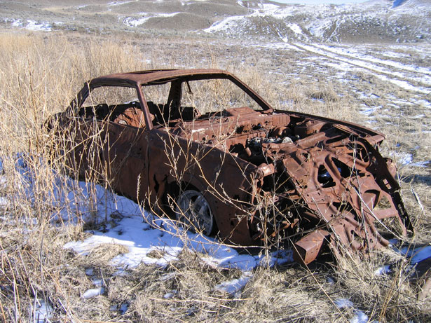 Description Abandoned Car in the Grasslands in the early spring