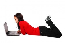 Femme couchée avec un ordinateur portabl