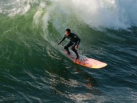 Longboard surfující kapky na vlně