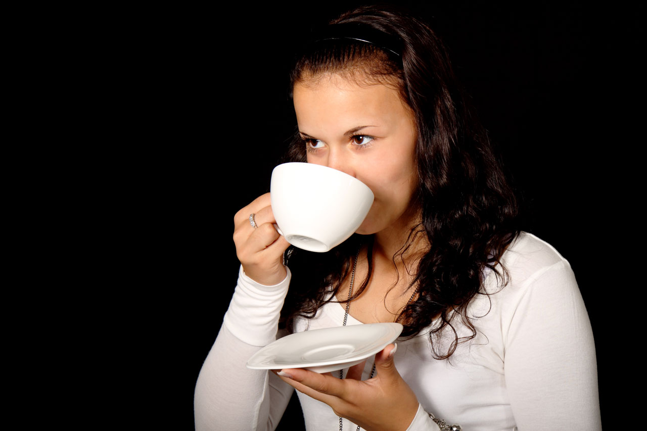Mladá žena pije čaj