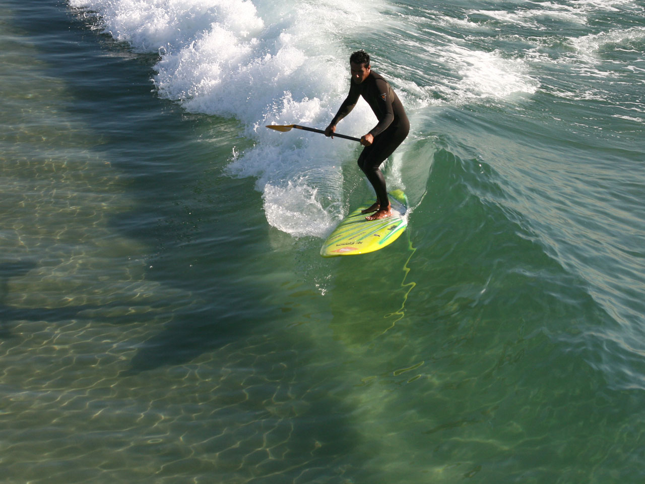 Paddleboarder capturile un pahar wave