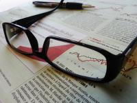 Szemüveg és toll egy újság