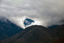 Pico nevado através das nuvens