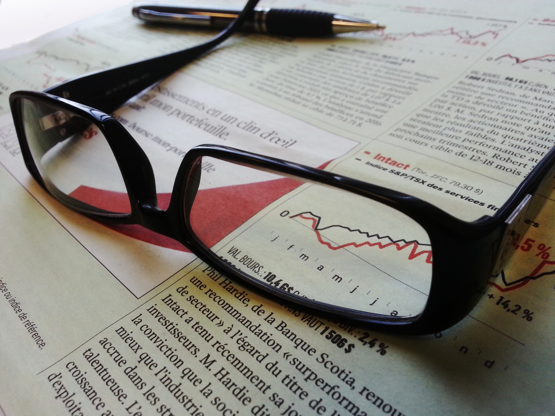 Glasögon och penna på en tidning