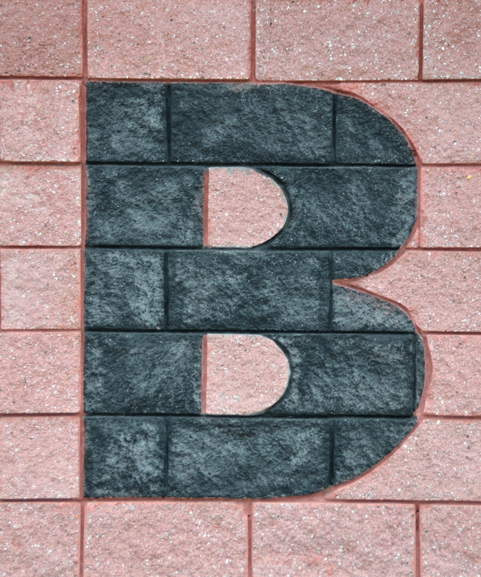 Litera B na ceglany mur