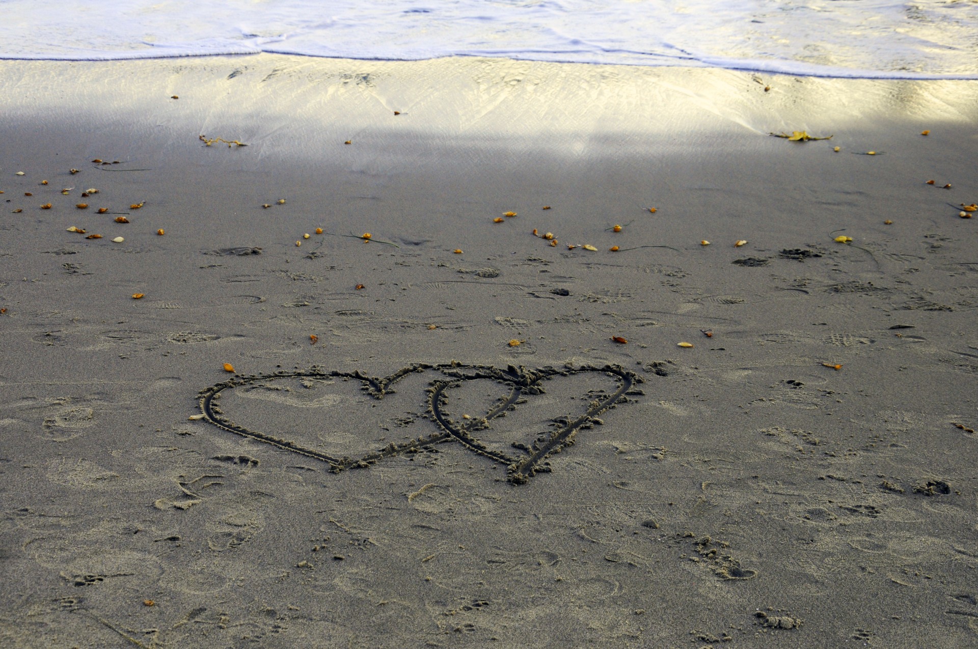 Două inimi desenate în nisip