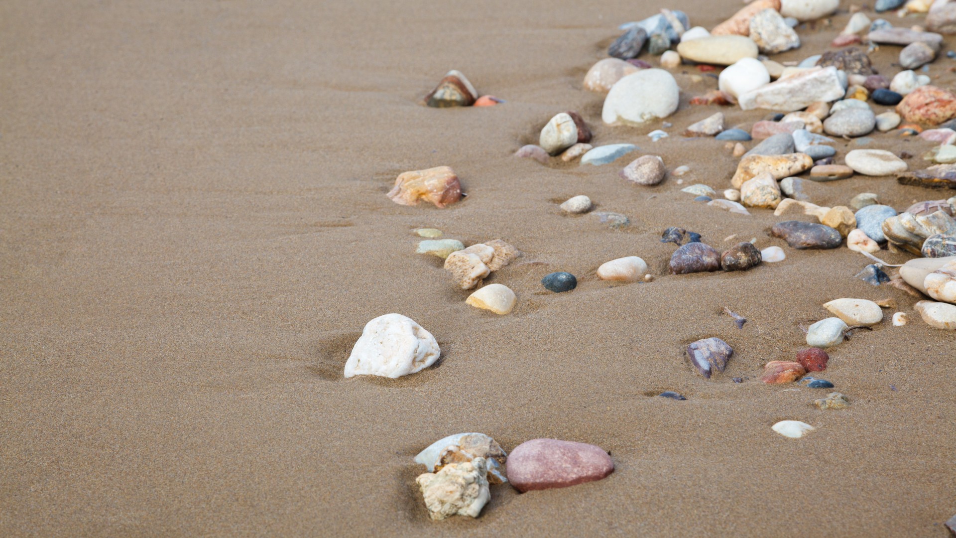 Pietricele pe plaja cu nisip