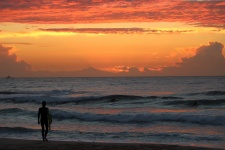 Surfista que aprecia Mar do por do sol