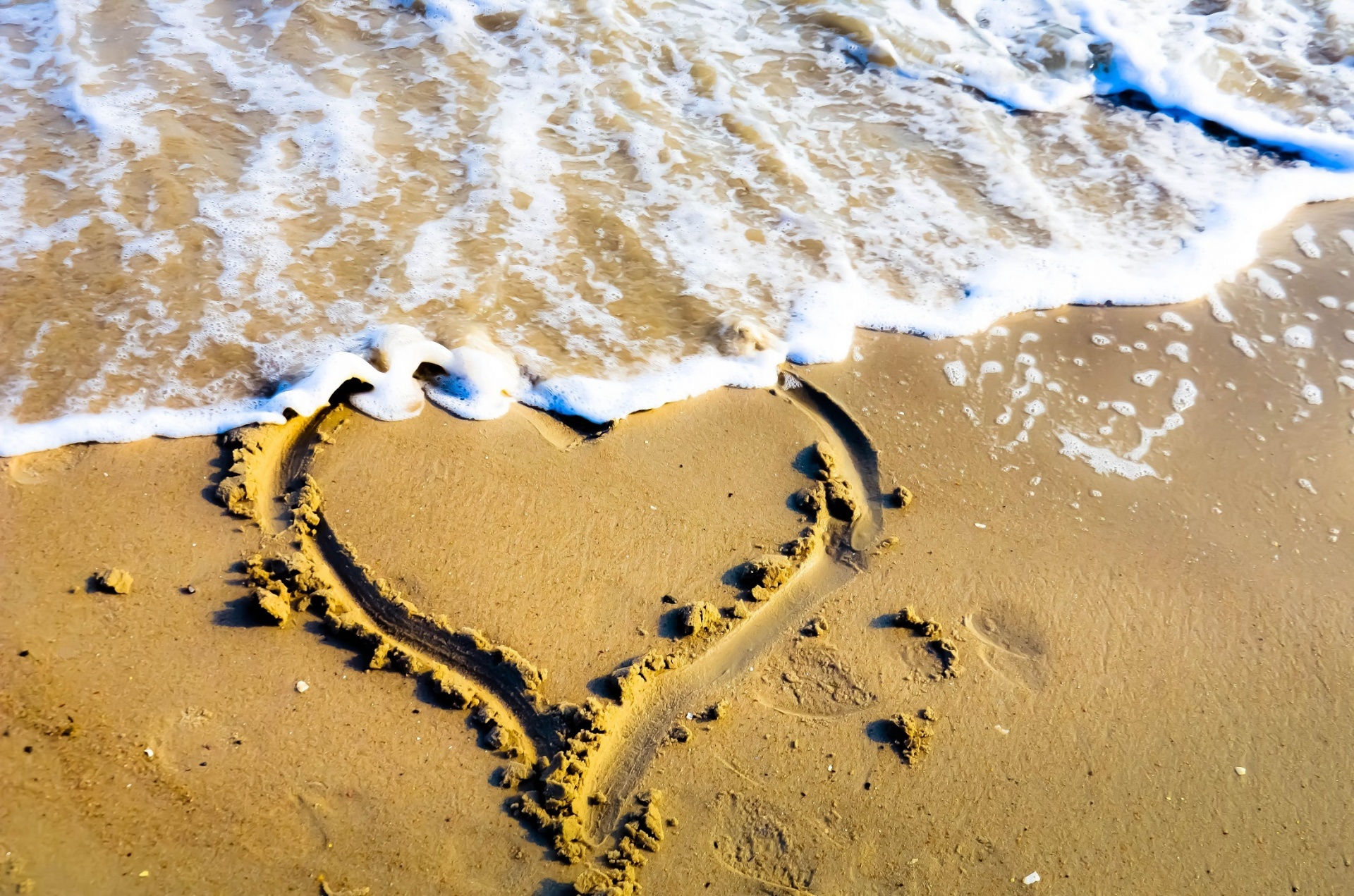 Coração desenhado na areia