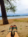 Fötterna på sjön strand