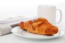 Croissant newspaper and tea