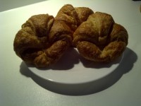 Trei croissant pe o placă albă