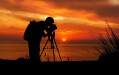 Fotograf při západu slunce silueta