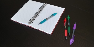 Cuaderno abierto con bolígrafos