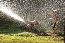 Crianças jogando no sprinkler de água