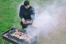 Hombre asando carne al aire libre