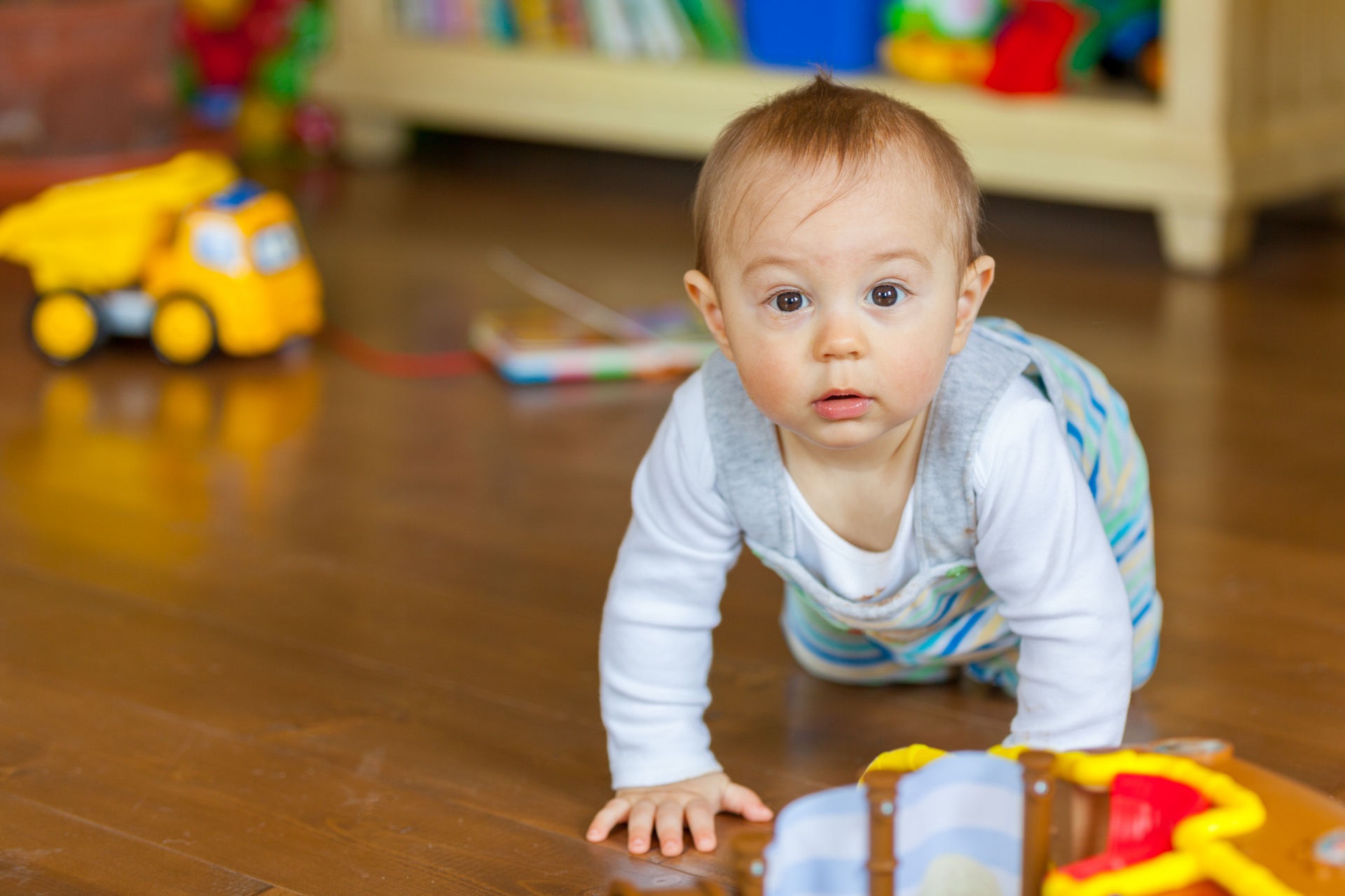 An infant crawling on the floor with toys around as done in the Strange Situation.^[[Image](https://www.publicdomainpictures.net/en/view-image.php?image=248590&picture=toddler-in-playroom) is in the public domain]