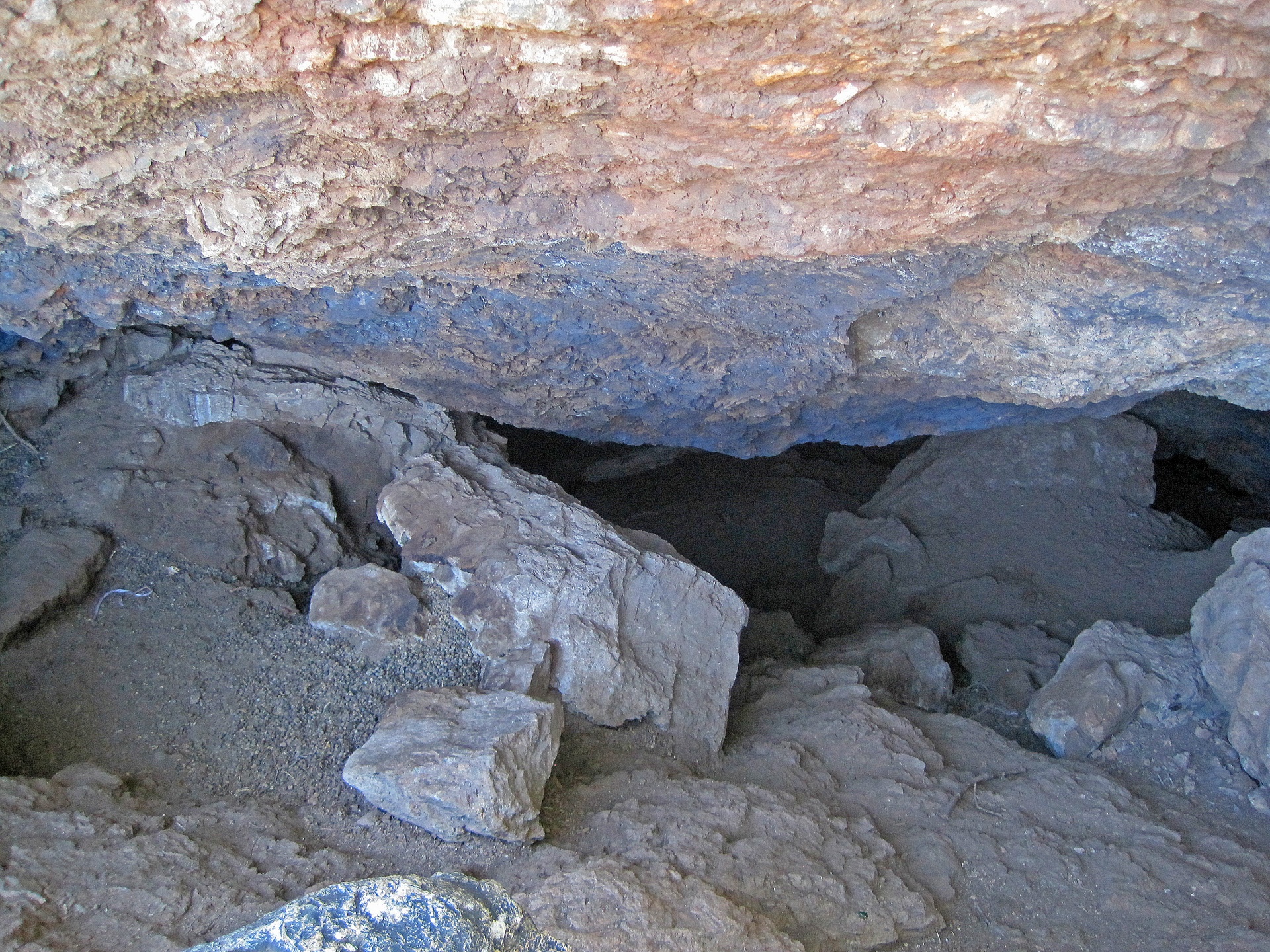 Grijs zand bij de ingang van de grot