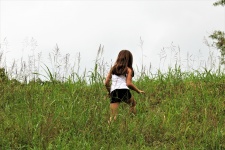 Petite fille grimper la colline herbeuse