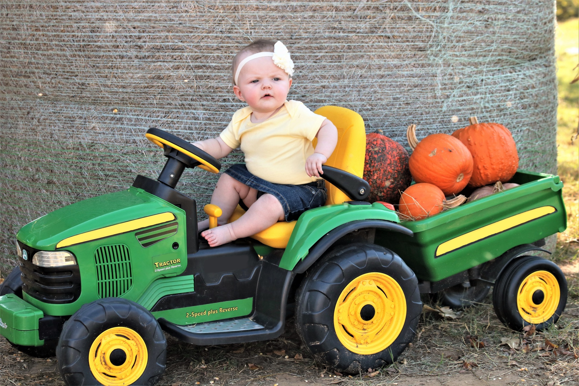 Baby On Tractor With Pumpkins