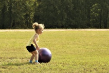 Little Girl Rolling Big Ball