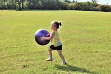 Little Girl Running With Big Ball