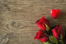 Rote Rosen und Herz auf Holz