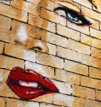 Fața fetei pictată pe peretele cărămizii