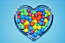 Caramelle colorate nel piatto del cuore