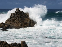 Welle bricht über Rock