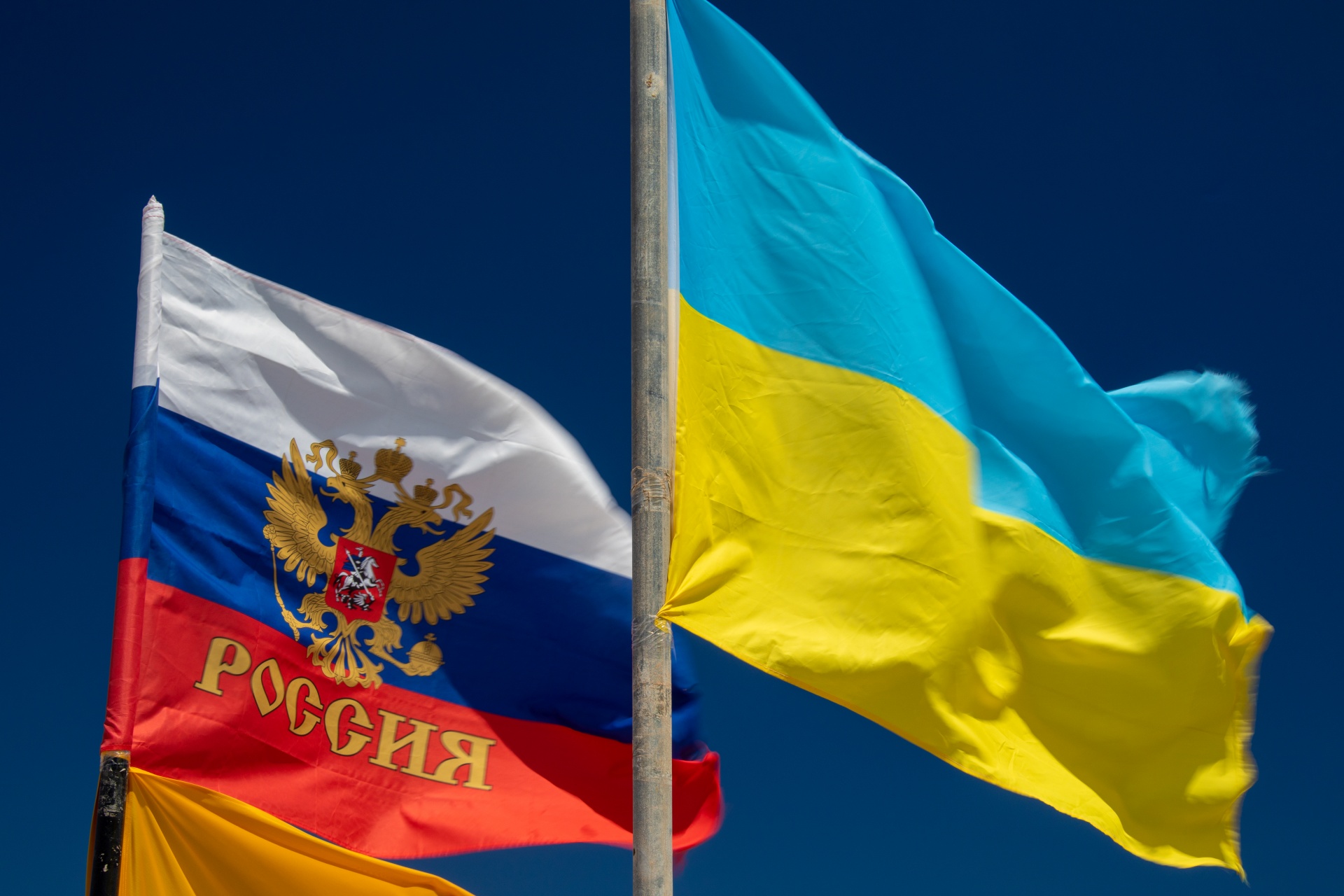 Russian and Ukrainian flag against blue background
