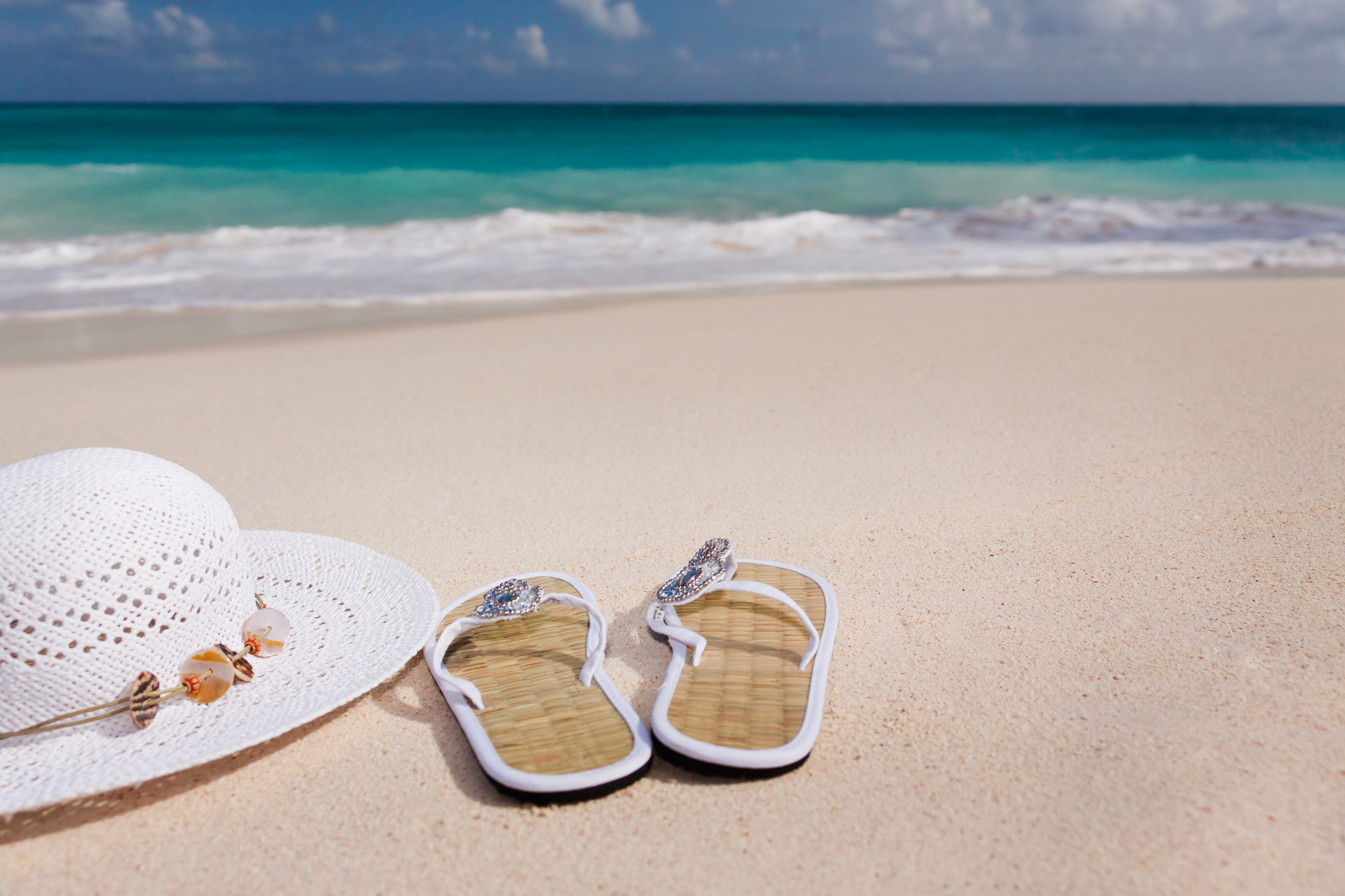 Chapéu e sandálias de dedo na praia
