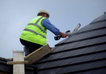 Pracownik budowy strony na dachu