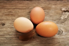 Tři hnědá vejce na dřevěný stůl