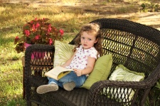 Little Girl Reading Book Outdoors