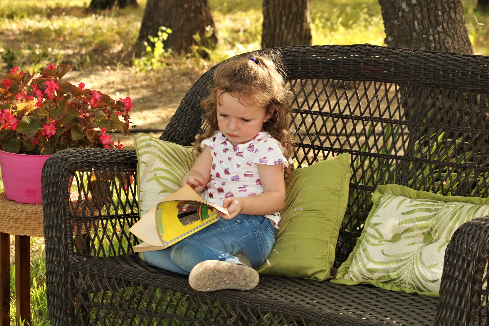 Malá dívka čtení knihy venku