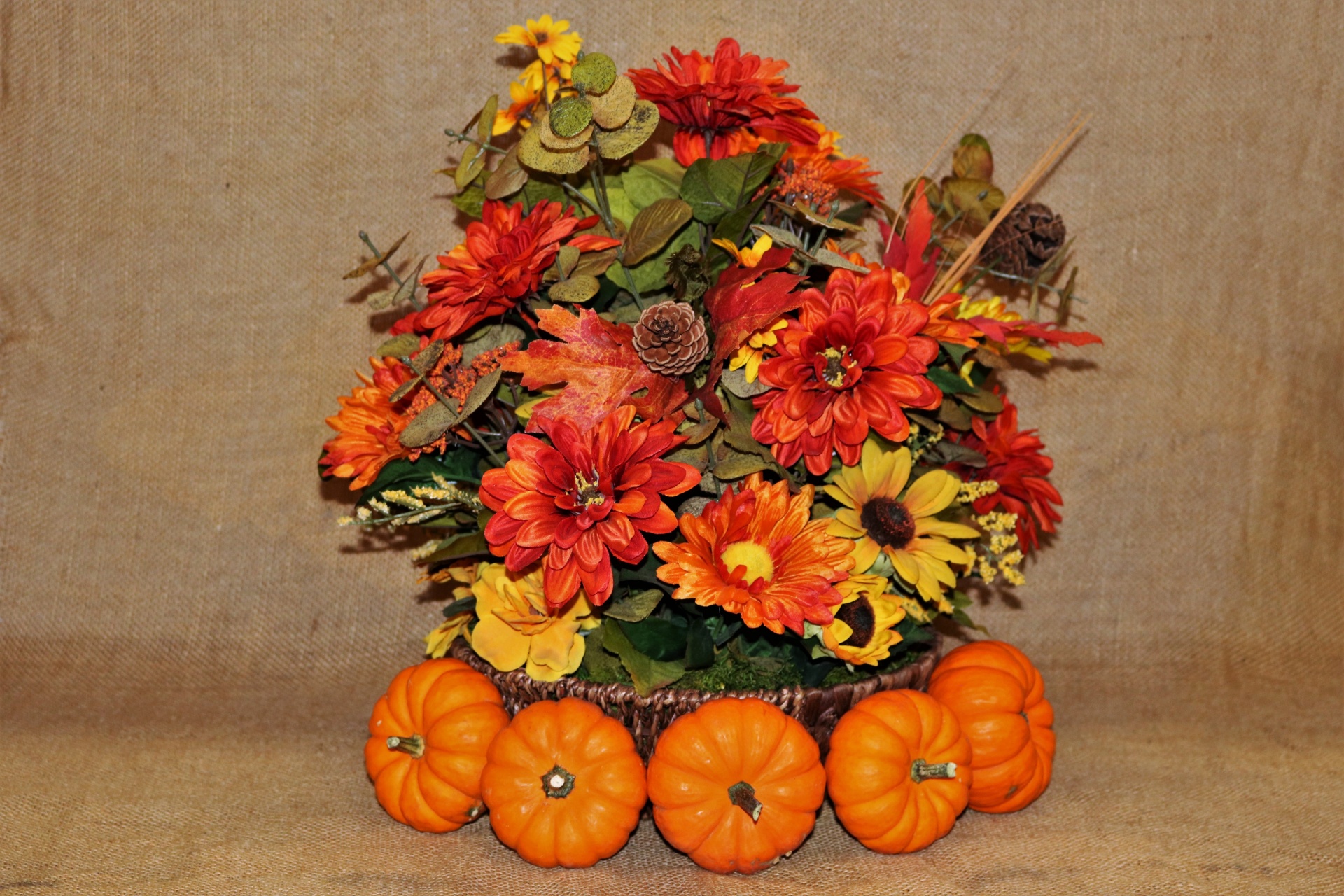 Calabazas y flores de otoño en arpillera