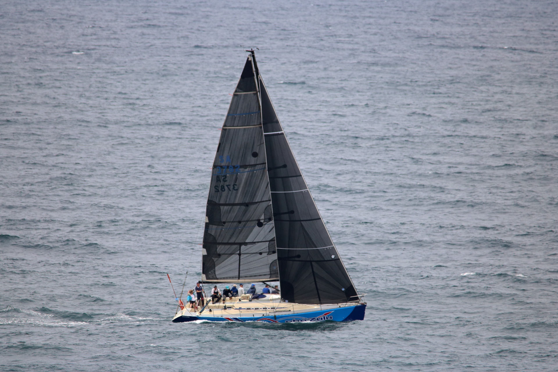 Yacht med besättningen som seglar på hav