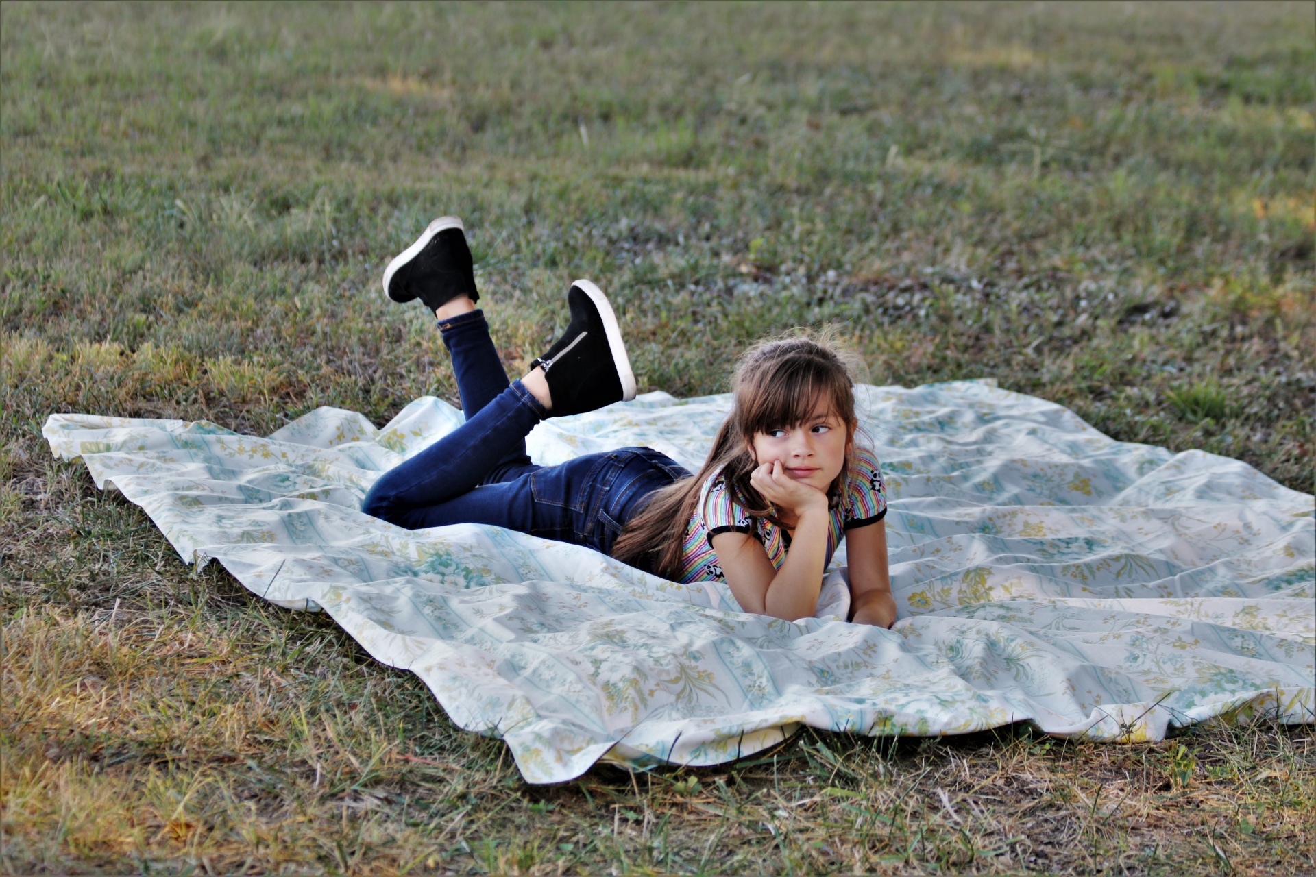 Mladá dívka na dece v trávě