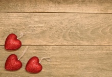 Tři červené třpytivé srdce na dřevo