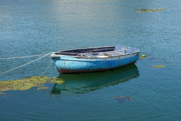 Small Wooden Fishing Boat With Fishing Net In Calm Water Stock