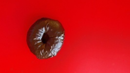 Шоколадный пончик на красном