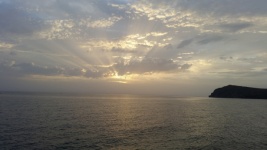 Bewolkte zon boven zee