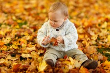 Chłopak siedzi w parku jesienią