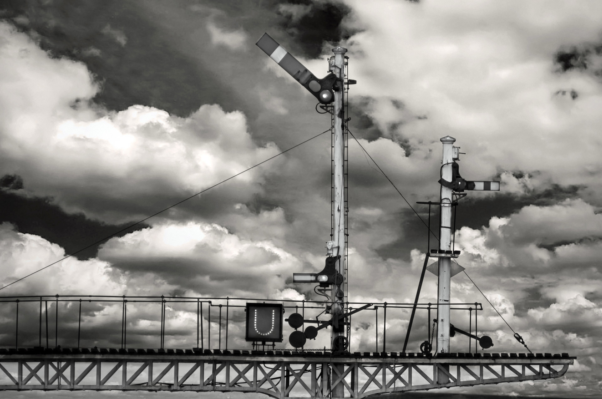 Sinalização ferroviária e céu nublado