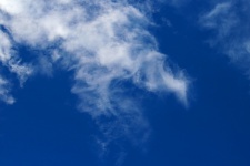 Wispy cloud smudges in a blue sky
