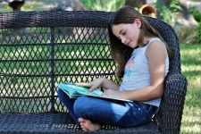 Young Girl Reading Book Outside