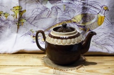 Brązowy ceramiczny czajniczek i jedwabna