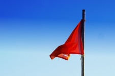 Steag roșu rupt zburând în vânt