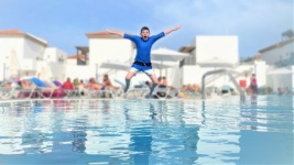 Garçon sautant dans la piscine en vacanc